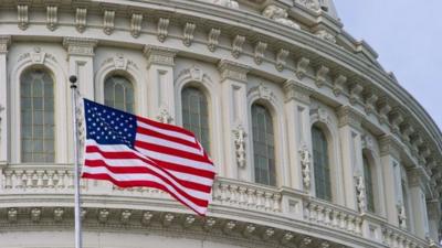 The US Flag flies outside the Capitol