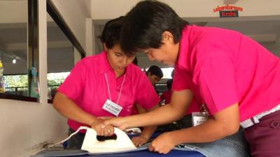 Student being taught to iron