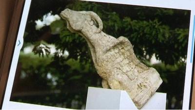 A sculpture of a goat gargoyle