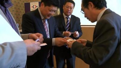 Chinese businessmen exchanging cards