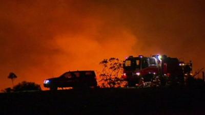 Emergency vehicles with fire in the background