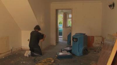 Builders repairing flooded house