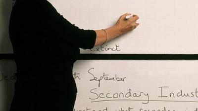 Teacher writing on whiteboard