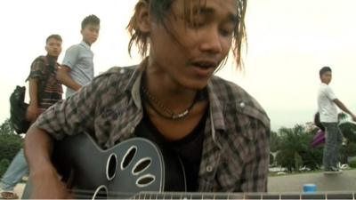 Young man playing guitar in the street