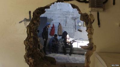 FSA fighters seen through hole in wall in Aleppo