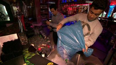 Barman putting ice in a bucket