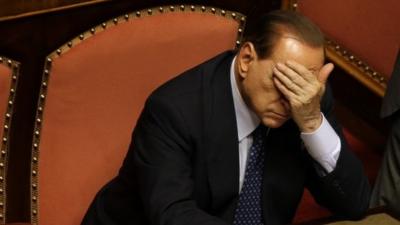 Silvio Berlusconi with his hand over his eyes in the senate in Rome