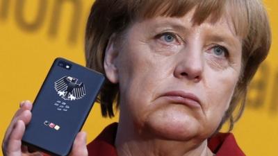 German Chancellor Angela Merkel holds a BlackBerry Z10 smartphone featuring high security Secusite software,