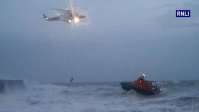 Helicopter and lifeboat in stormy seas