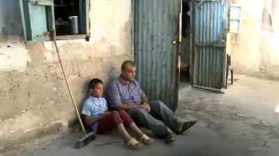 A Palestinian refugee and his son outside their home in the Gaza Strip