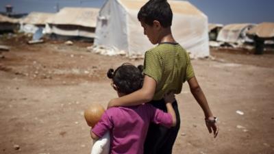 Syrian refugee children walk in the Bab al-Salam refugee camp in Syria's northern city of Azaz