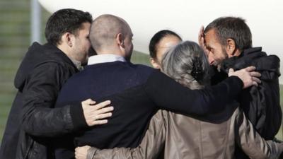 Former hostage Daniel Larribe (R) is welcomed by his family