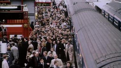 Passengers get off a train onto a crowded platform