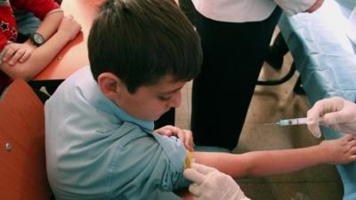 A Syrian student receives a vaccination as part of a UNICEF-supported vaccination campaign at a school in Damascus