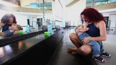 Woman breastfeeding child in a dance studio