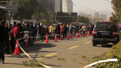 People stand on a street after an explosion outside a provincial headquarters