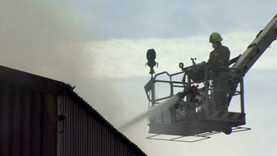 Firefighter with a hose on a hydraulic platform