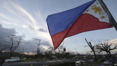 Philippine flag surrounded by storm damage