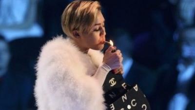 Miley Cyrus lights a cigarette on stage during the 2013 MTV Europe Music Awards