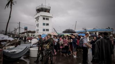 People at Tacloban airport wait to be evacuated