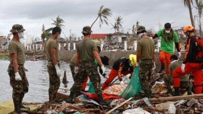 Military personnel and members of the Philippines Special Reaction Unit search for the bodies of victims near Tacloban