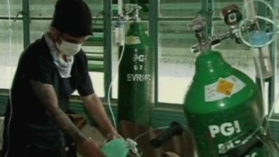 A Filipino nurse in a makeshift emergency room helps a patient