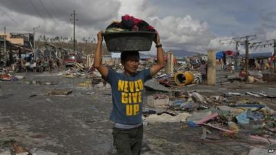 A man carrying goods through the disaster zone at Tacloban, in the Philippines