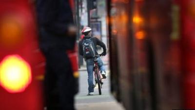 Cyclist between two buses in London