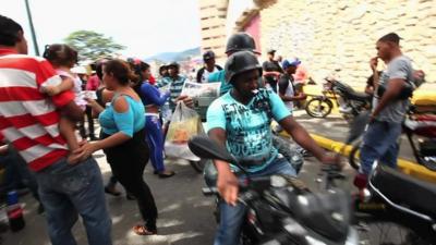 Motorbike weaving through a crowd