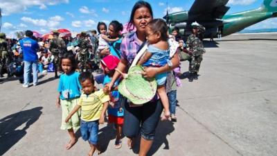 Survivors wait for a military plane that will carry them to Manila at Tacloban airport on November 15, 2013 in Leyte