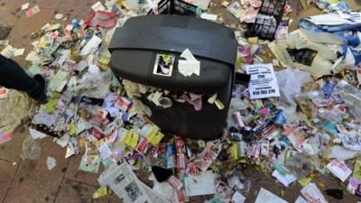 A street bin surrounded by rubbish is seen in the centre of Madrid on November 14, 2013 during an open-ended strike by street-sweepers against layoffs and salary cuts