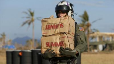 U.S. Marine carries packages of drinking water to a waiting helicopter to be deployed to survivors of Super Typhoon Haiyan at Tacloban airport