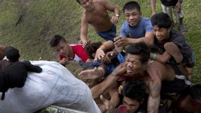 Villagers stranded by last week's Typhoon Haiyan scramble for aid from a U.S. Navy Sea Hawk helicopter