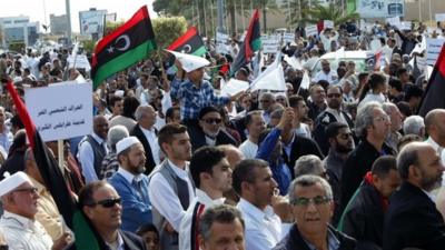 Protesters march during a demonstration calling on militiamen to leave, in Tripoli