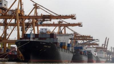 Cargo ships are loaded with containers as they are docked at the port near Chao Phraya river in Bangkok