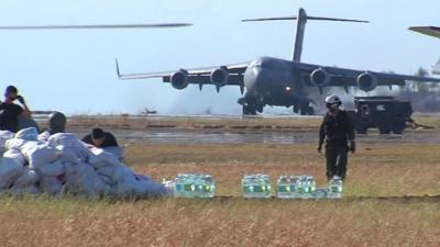 Landing plane, sacks of food, bottles of water