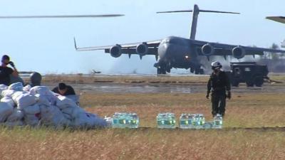 Landing plane, sacks of food, bottles of water