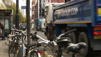 A lorry passes parked cycles