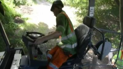 Worker resurfacing road