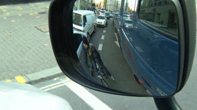 View of cyclist through lorry's mirror