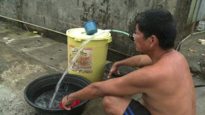 Man in Tacloban using neighbours water supply