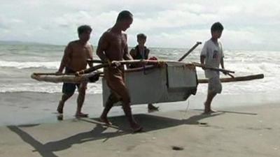 A fridge boat being lifted on to a beach