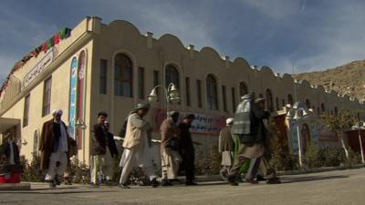 Men walking past buildings