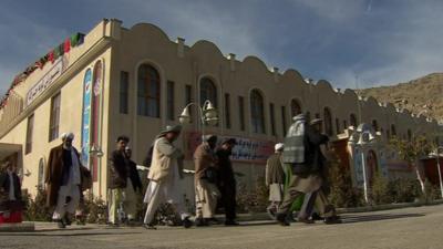 Men walking past buildings