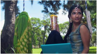 A businesswoman posing for the Saris to Suits calendar