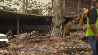 Digger at site of collapsed mall