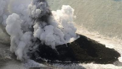 Island with smoke and lava spewing out of it