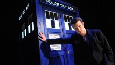 Matt Smith stands next to Tardis