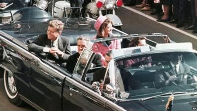 JFK and wife Jackie drive through Dallas in the motorcade