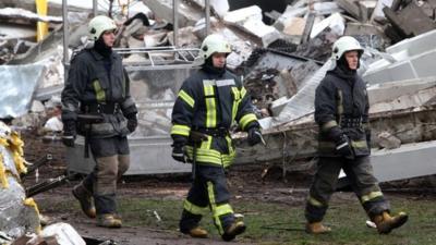 Rescuers walk at the site of the Maxima supermarket in Riga on November 23, 2013, after the roof of the building caved in on shoppers on November 21